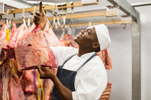 afro american butcher handing red meat photo
