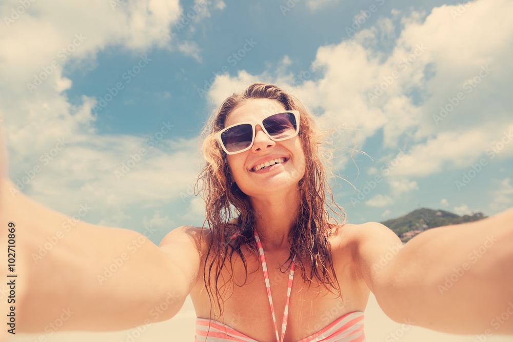 Beautiful young woman doing selfie on the beach Beautiful young woman doing selfie on the beach