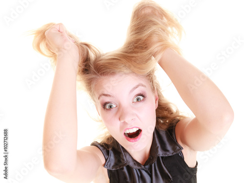 Angry furious woman screaming and pulling messy hair