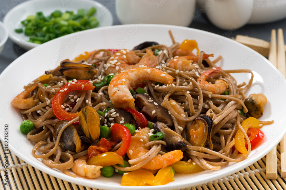 Asian buckwheat noodles with seafood and vegetables, closeup