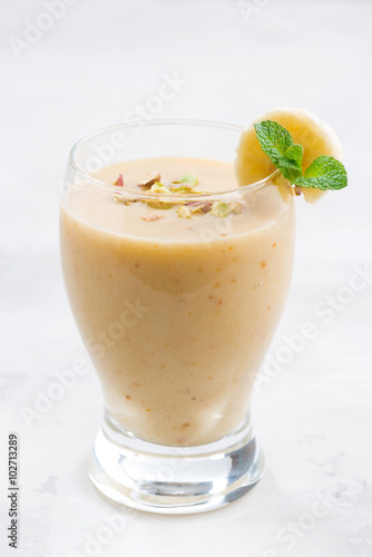 banana smoothie in a glass, vertical