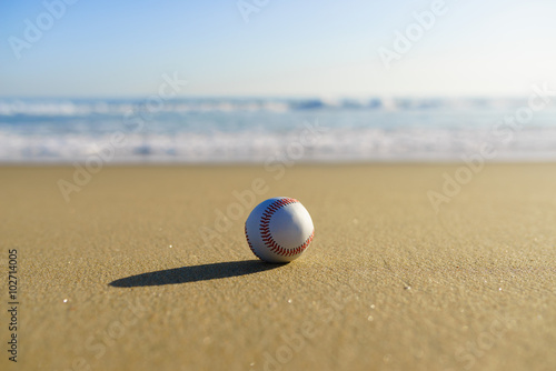 Baseball at a California beach with white wave in pacific ocean