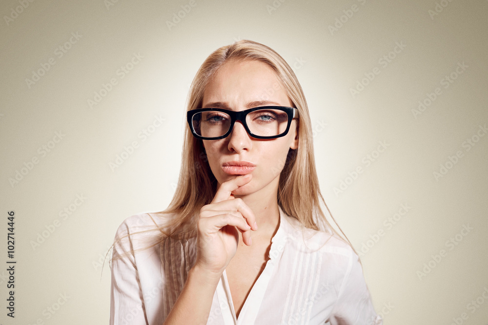 Healthy young thinking woman in glasses looking at camera on background with empty copy space