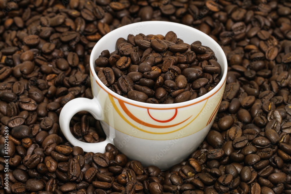 Coffeecup in roasted coffee beans