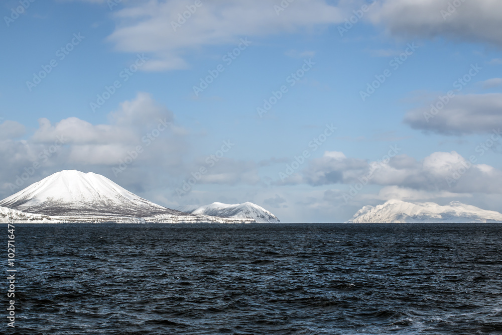 snow-covered volcano in the winter on the island in the clouds