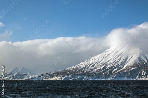 snow-covered volcano in the winter on the island in the clouds