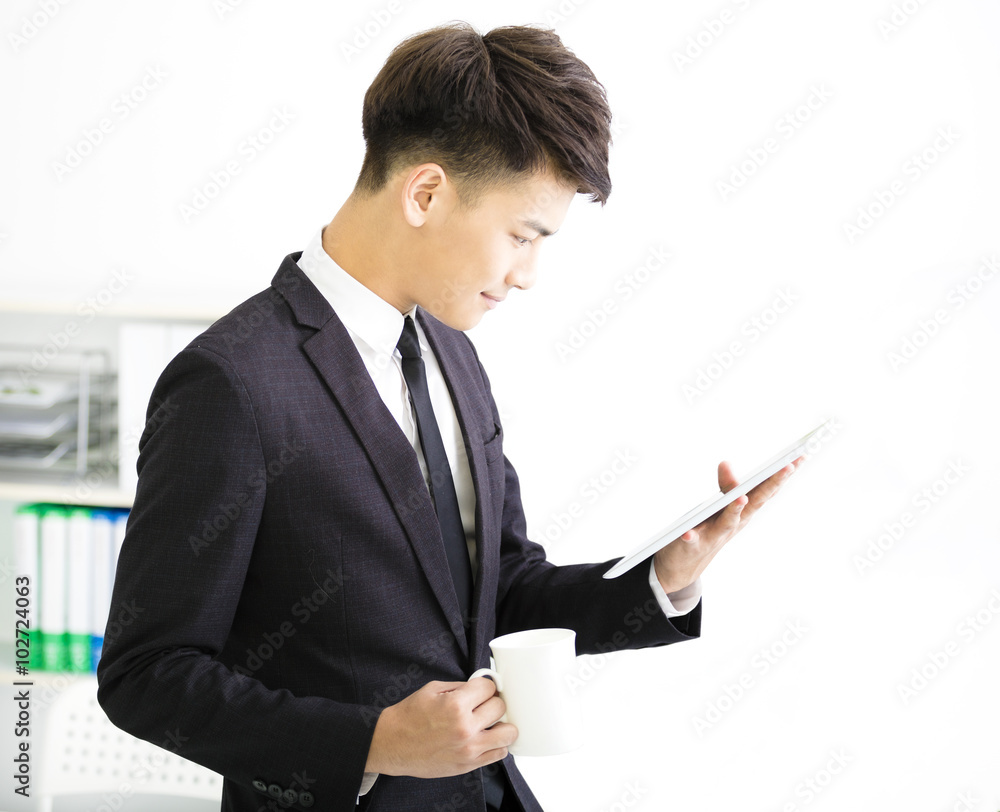 happy young businessman watching tablet in office happy young businessman watching tablet in office