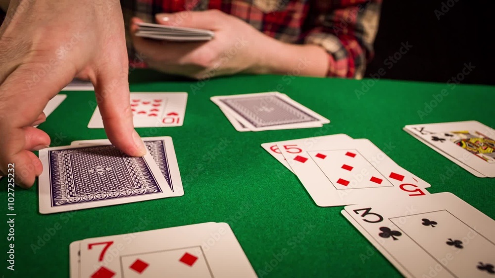 Close up of female hands holding cards and playing solitaire Close up of female hands holding cards and playing solitaire