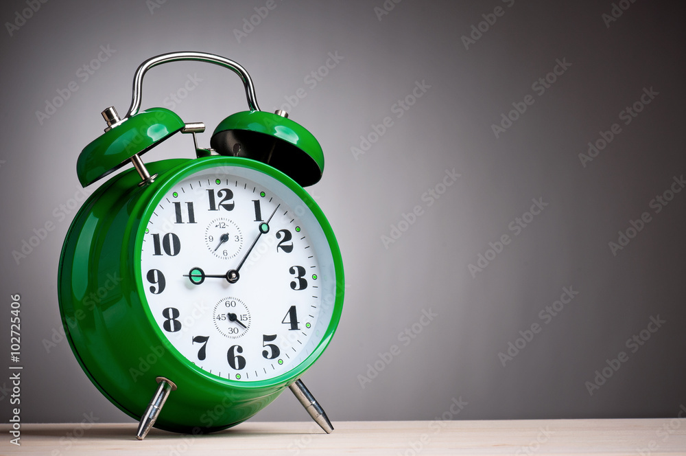 Big green alarm clock on grey Big green alarm clock on grey