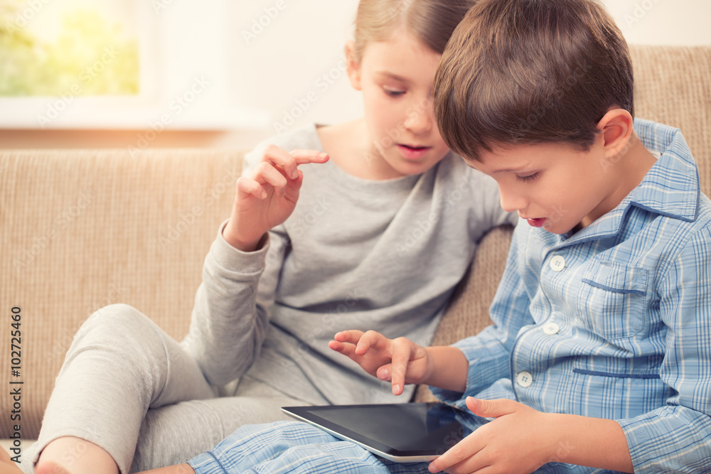 Naklejka premium Children playing with tablet pc