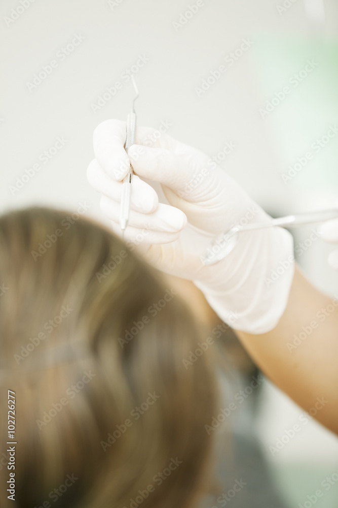 Closeup of dentist examining young woman's teeth Closeup of dentist examining young woman's teeth
