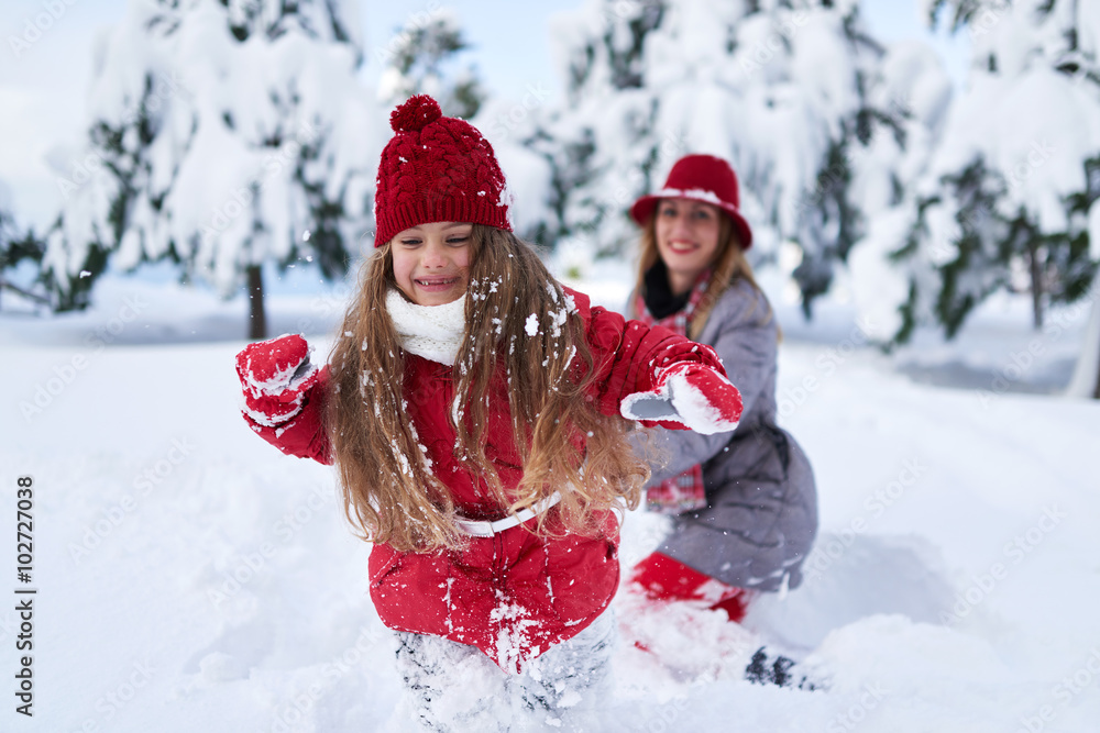 daughter with mother play in snow-covered park daughter with mother play in snow-covered park