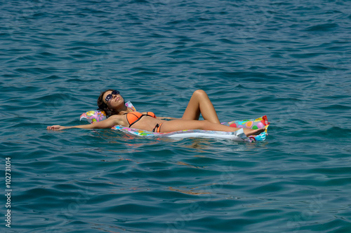 Woman on inflatable beach mattress © pavelsm27