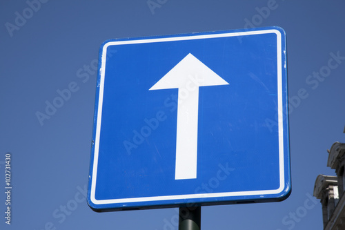 Blue and White Arrow Sign on Sky Background