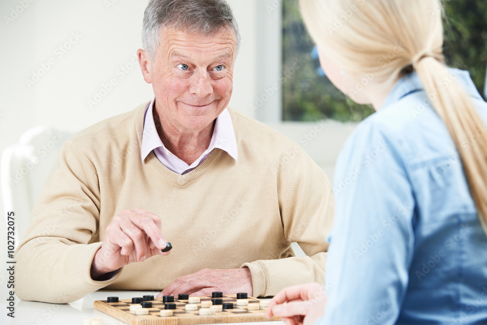Senior Man Playing Checkers With Teenage Daughter Senior Man Playing Checkers With Teenage Daughter