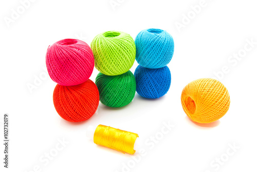 different colored spools of thread on white