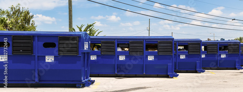 Blue Recycle containers lines up in a row.
