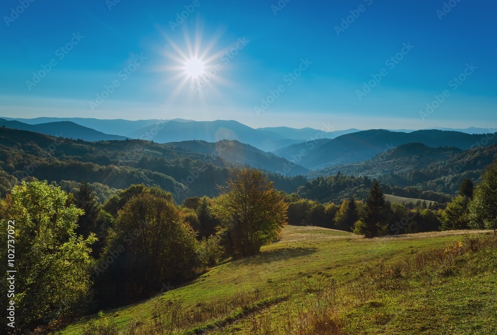 Carpathian Mountains. The autumn sun with rays, mountains and hills