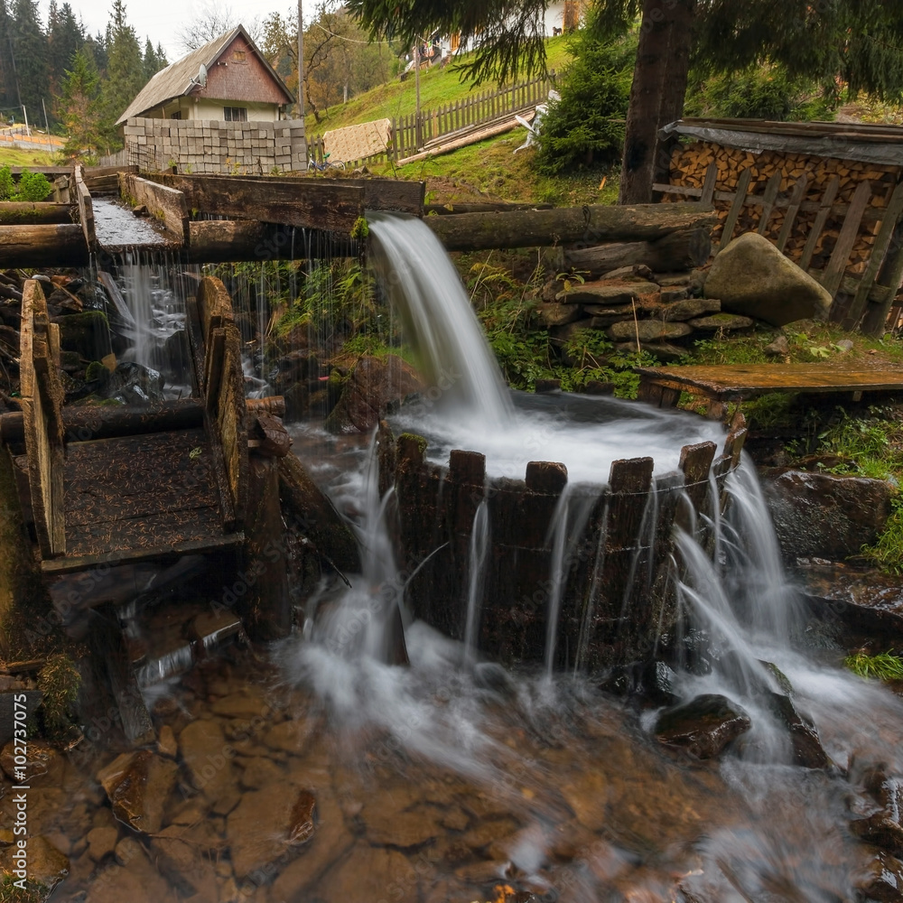 Obraz premium Carpathian Mountains. The mountain river in the autumn forest, tub with water.
