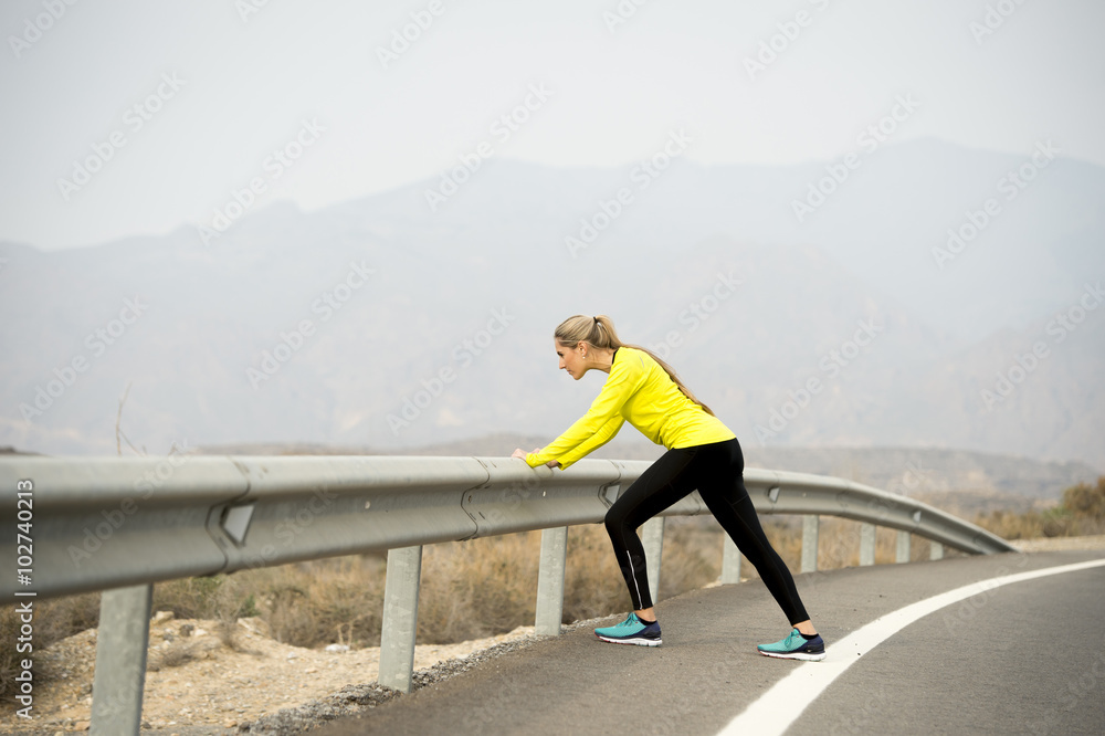 sport woman stretching leg muscle after running workout on asphalt road with dry desert landscape in hard fitness training session sport woman stretching leg muscle after running workout on asphalt road with dry desert landscape in hard fitness training session