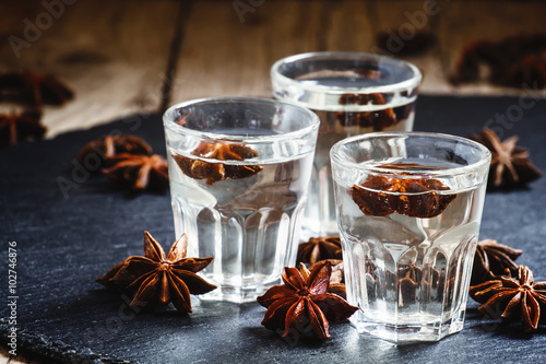 Homemade anise liqueur in a glass on a dark background, selectiv photo