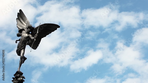 The Statue of Eros, a prominent landmark in Piccadilly Circus, London, UK; time lapse clouds with copy space.