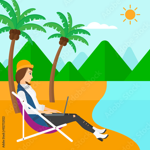 Business woman sitting in chaise lounge with laptop.