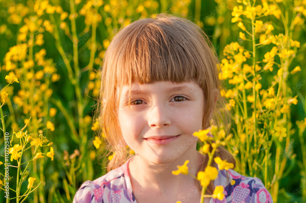 Girl smiling in a field with yellow flowers Girl smiling in a field with yellow flowers