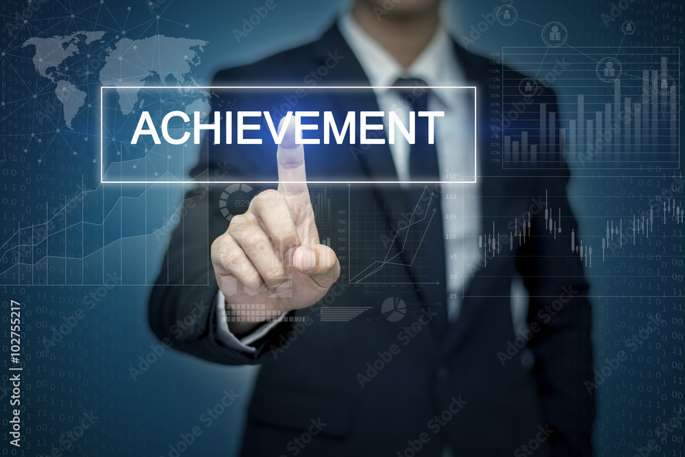 Businessman hand touching ACHIEVEMENT button on virtual screen Businessman hand touching ACHIEVEMENT button on virtual screen
