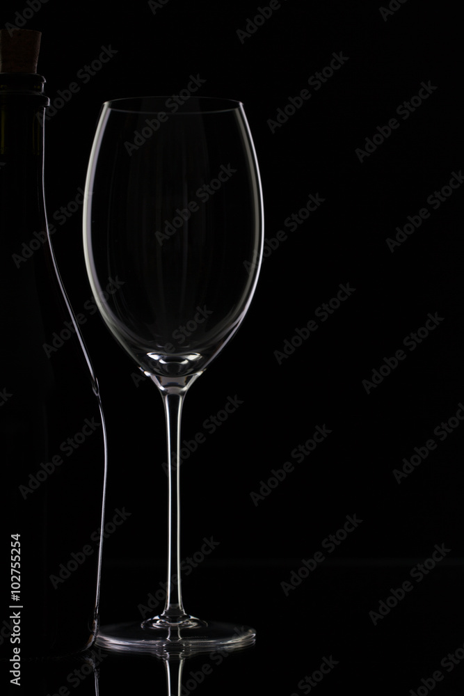 Bottle and glass on the black background