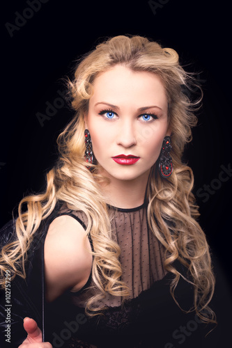 Beautiful fashion model girl with blond hair. Portrait of glamour woman with bright makeup isolated on black background.