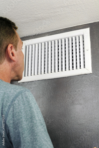 Man Looking Into Air Duct