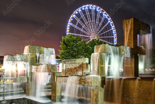 Vibrant Lights Illuminate Modern Fountain Sculpture in Night Scene 
