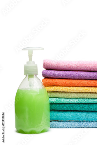 colorful towels and liquid soap isolated over white background