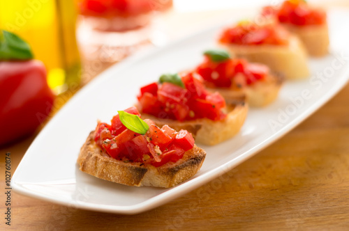 Italian tomato bruschetta served as appetizer, made with fresh ingredients like tomatoes, garlic, basil, bread and olive oil.