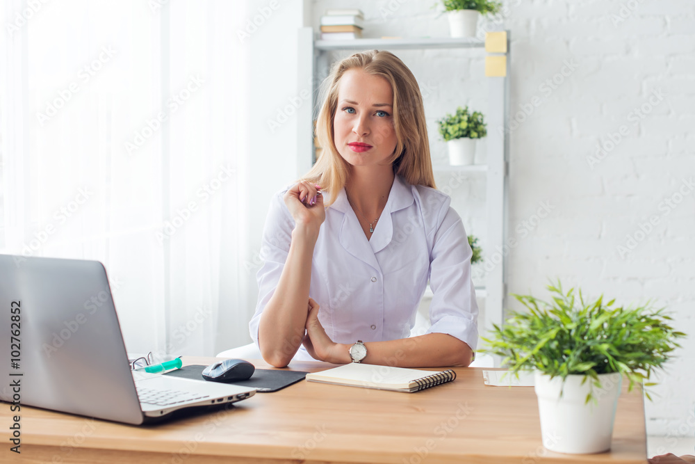 Portrait of physician working in her office sitting workplace. Portrait of physician working in her office sitting workplace.