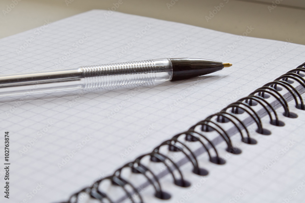 Pen and Notepad on grey background closeup Pen and Notepad on grey background closeup
