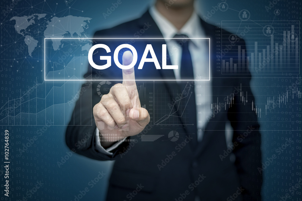 Businessman hand touching GOAL button on virtual screen Businessman hand touching GOAL button on virtual screen