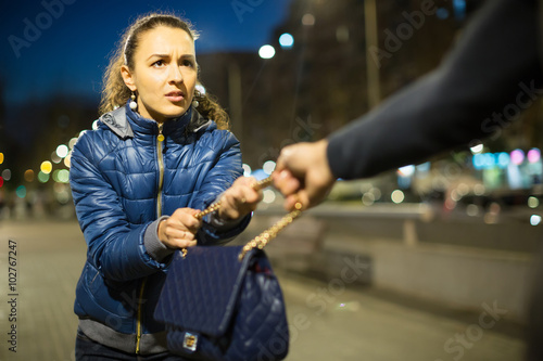 Tablou pe pânză Robber trying to steal bag at night.