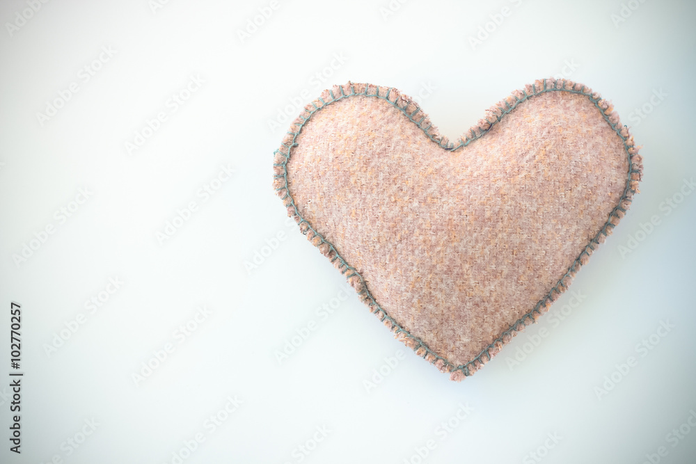 Pink handmade textile fabric heart on white background closeup Pink handmade textile fabric heart on white background closeup