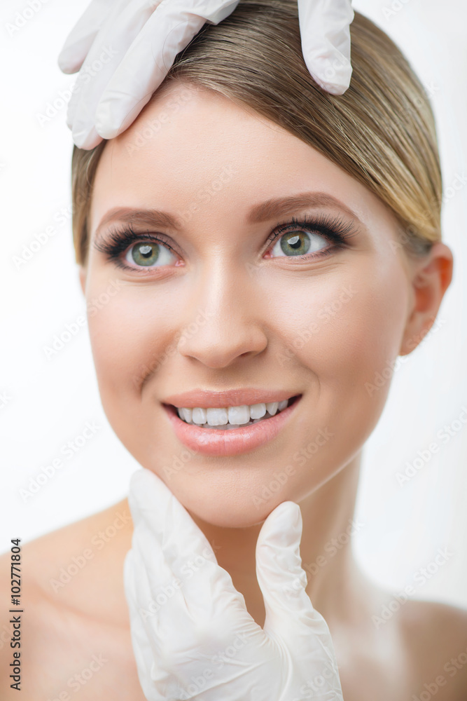 Professional surgeon examining face of pretty woman Professional surgeon examining face of pretty woman