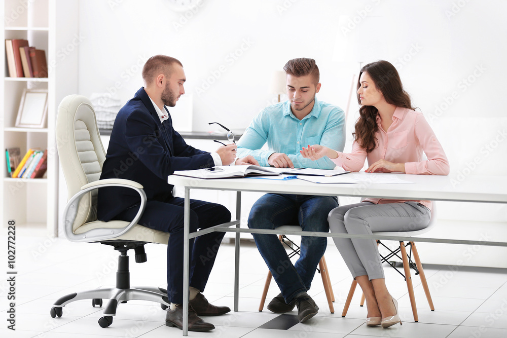 Happy family with estate agent,  in bright office