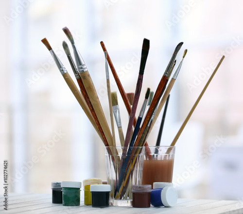 Drawing set with brushes and paints on white table