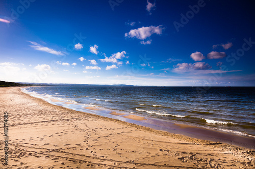 Fototapeta Naklejka Na Ścianę i Meble -  View of cloudy sky at sea with footprints on a beach
