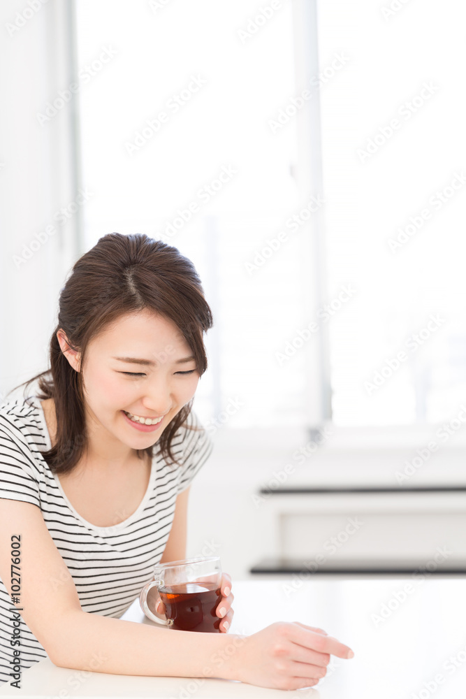 部屋でお茶を飲む女性