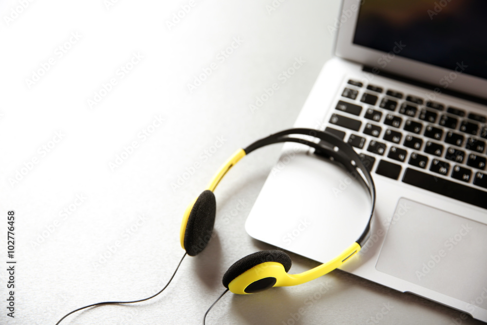 Headphones and laptop on table closeup Headphones and laptop on table closeup