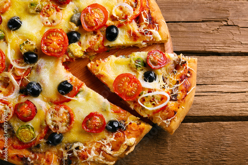 Delicious fresh pizza on wooden table, top view
