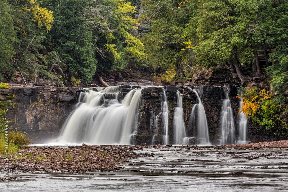 Fototapeta premium Manabezho Falls, a waterfall on the Presque Isle River, spills over a cliff at Porcupine Mountains State Park in Michigan's western Upper Peninsula.