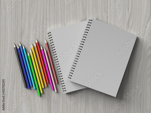 color pencil on checked notebook on wood background