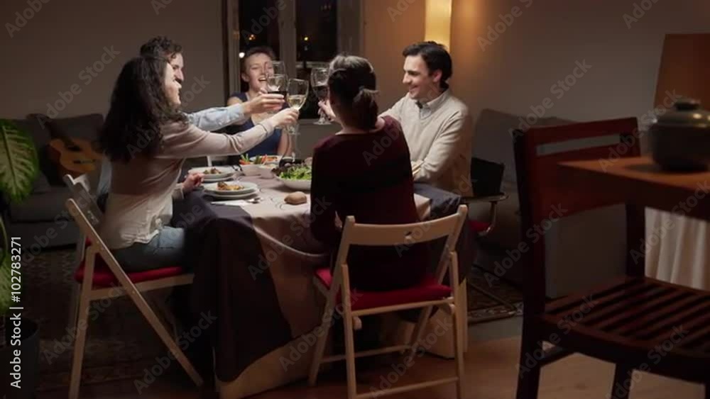 Friends toasting and smiling at dinner. The camera moves. 4K, UHD Friends toasting and smiling at dinner. The camera moves. 4K, UHD